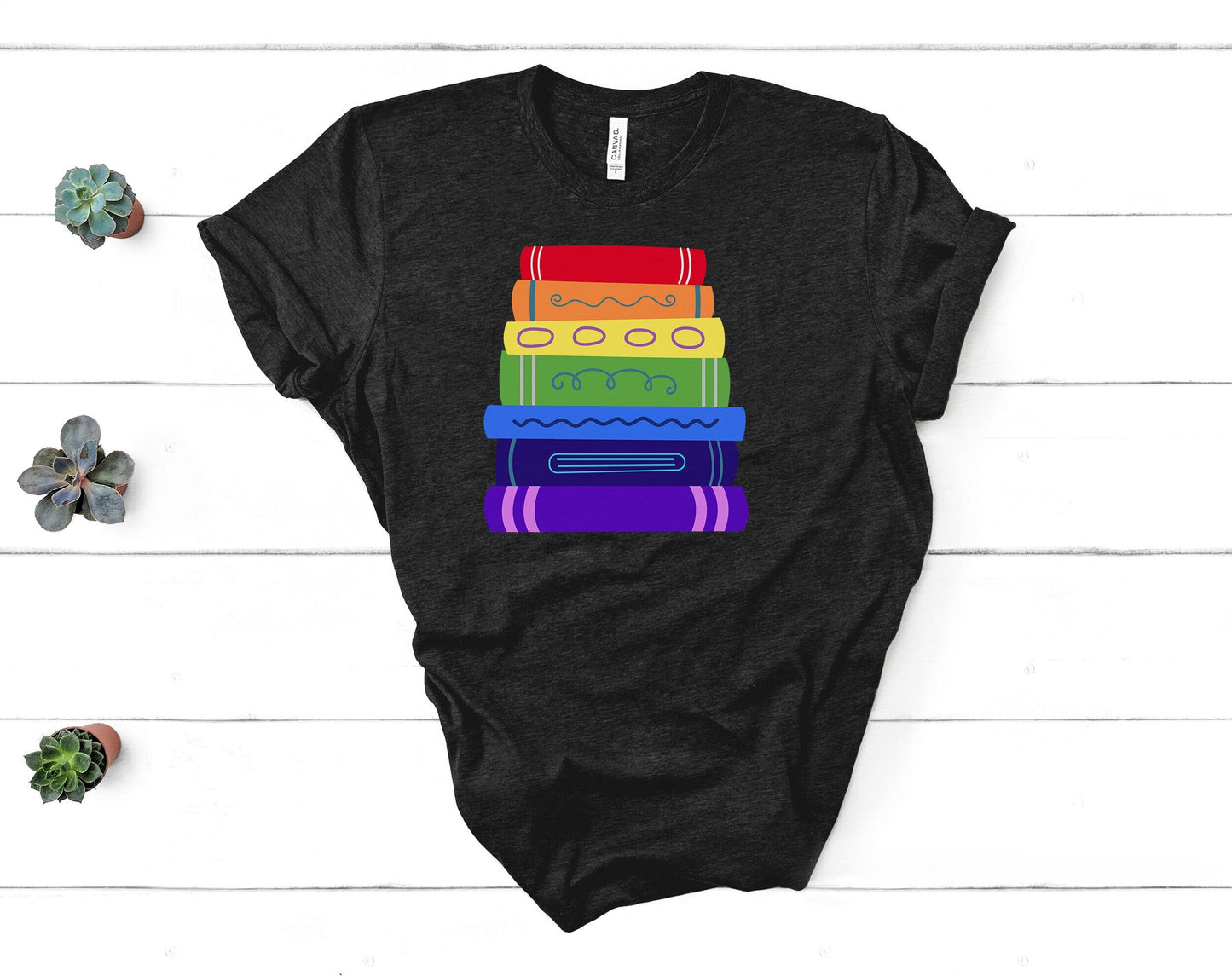 a soft tshirt with an illustrated rainbow colored bookstack